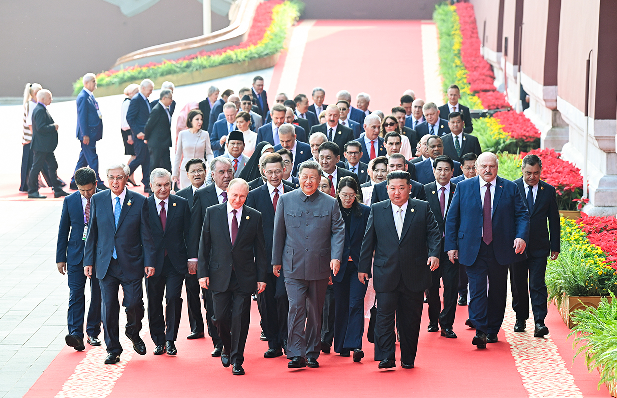 Президент России Владимир Путин, председатель КНР Си Цзиньпин и лидер КНДР Ким Чен Ын (слева направо на первом плане) кратко побеседовали по пути на трибуны.