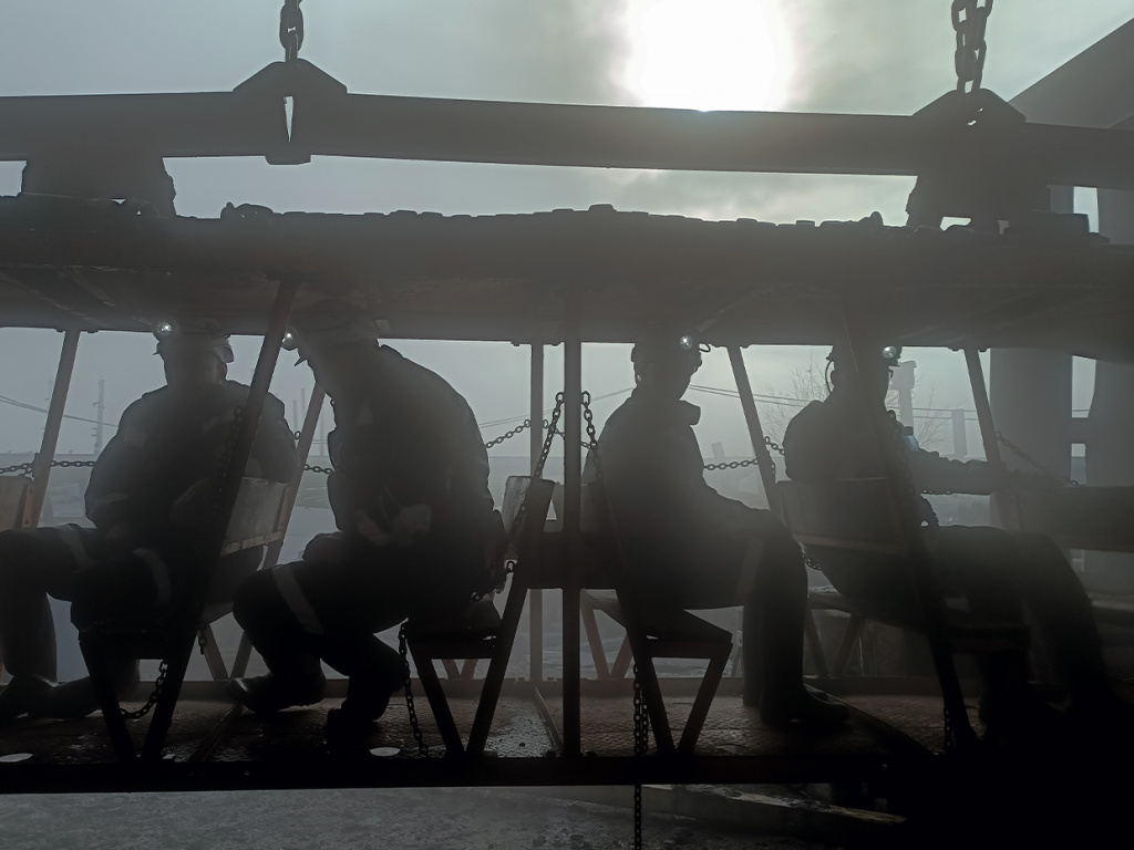 Спуск горняков в шахту на дизель-гидравлическом локомотиве («дизеле»), который движется по монорельсу